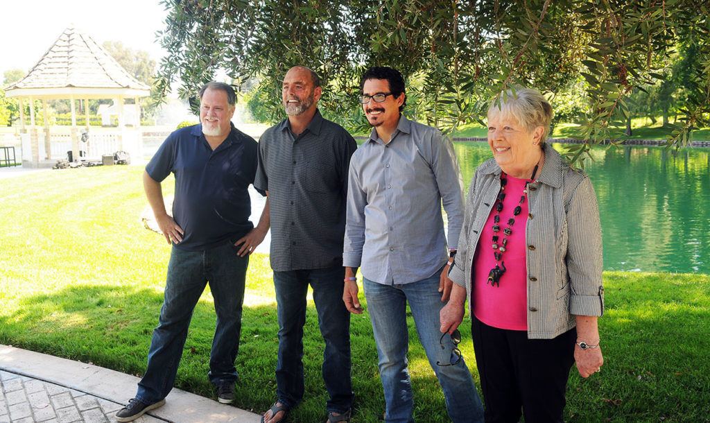 Smiling group of friends standing under a tree in a park